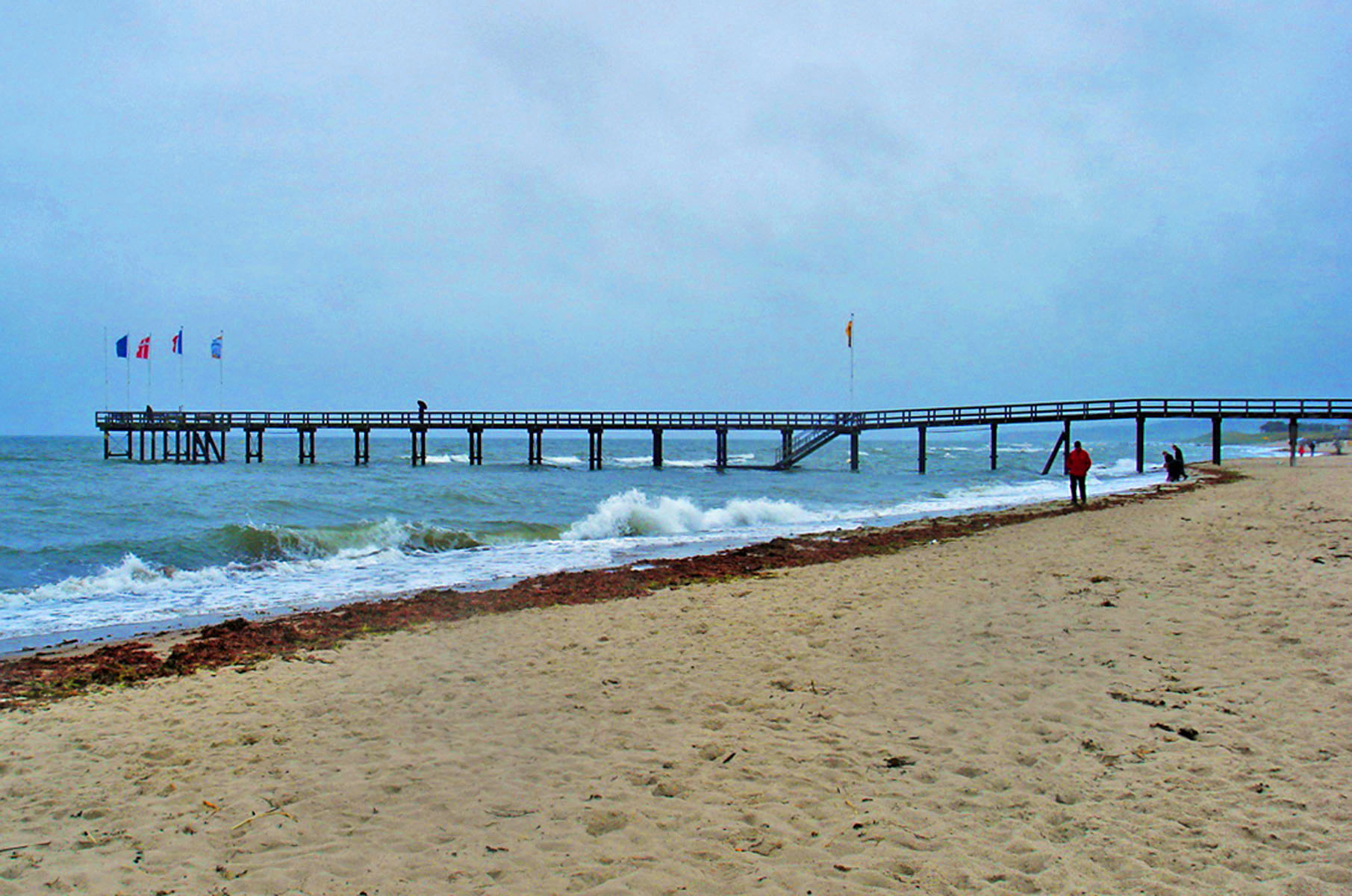 Strand mit Brückensteg ins Meer